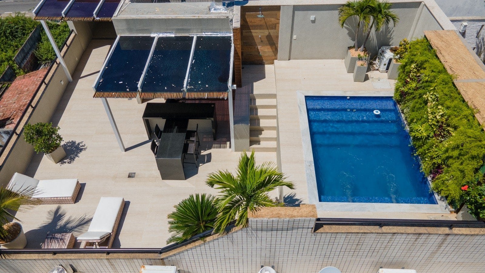 Piscina moderna ao ar livre com área de lazer e jardim tropical, ideal para imóveis de alto padrão na cidade de Monte Carlo.