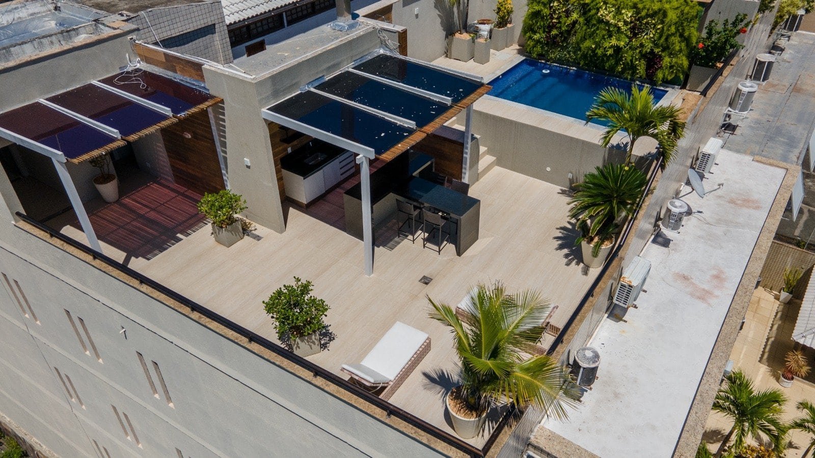 Luxuoso rooftop com piscina e espaço gourmet, projeto de arquitetura moderna pela Gruppo Monaco com detalhes em vidro, madeira e paisagismo sofisticado.