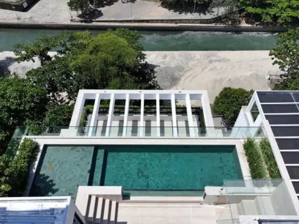 Piscina moderna com vista aérea, cercada por vidro, em residência de alto padrão, com espaço externo sofisticado e design contemporâneo em São Paulo, Brasil.