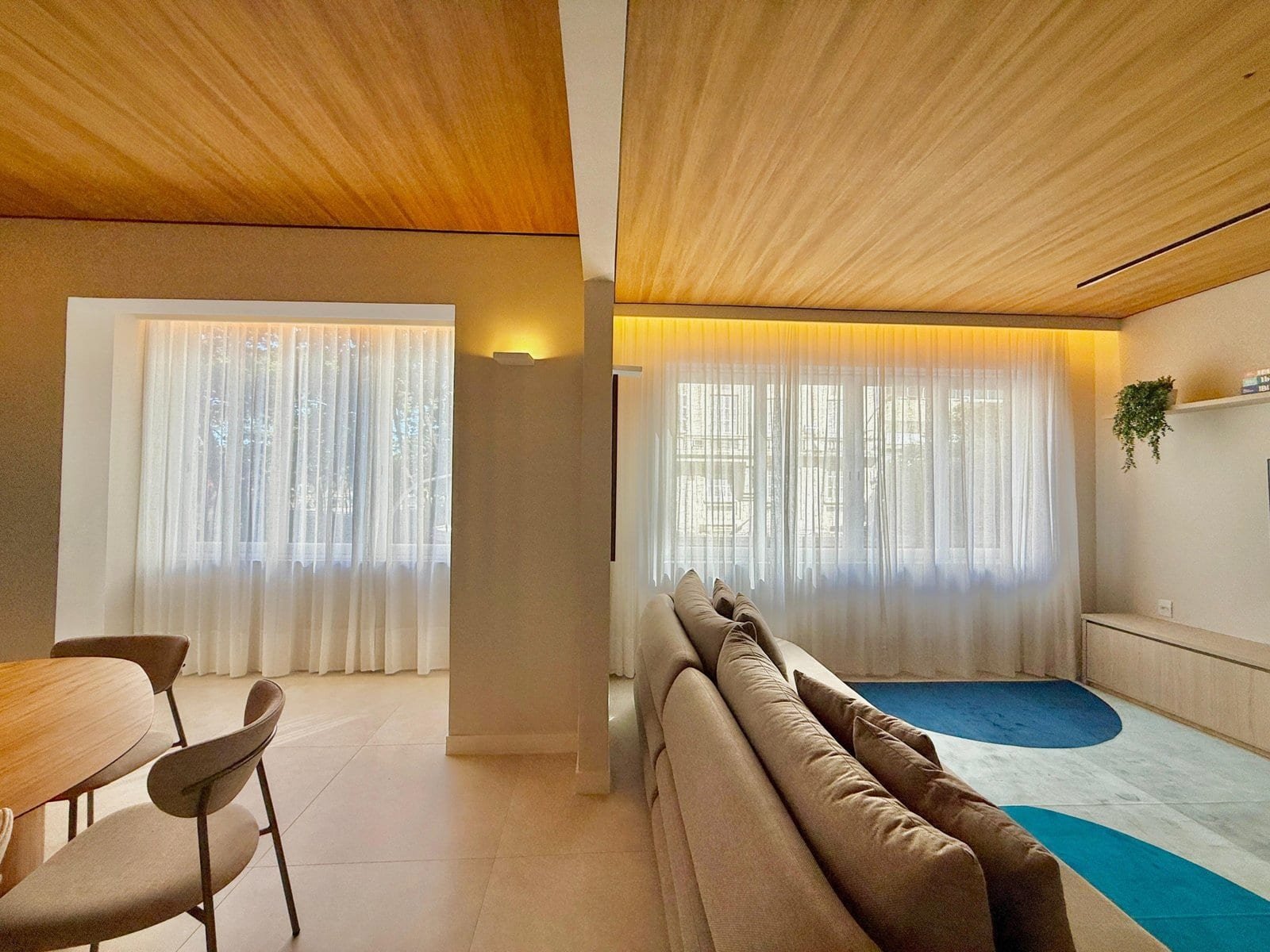 Luxuoso apartamento de alta qualidade com decoração moderna e elegância, amplo espaço com janelas de cortinas brancas e móveis confortáveis, ideal para viver com conforto e sofisticação.