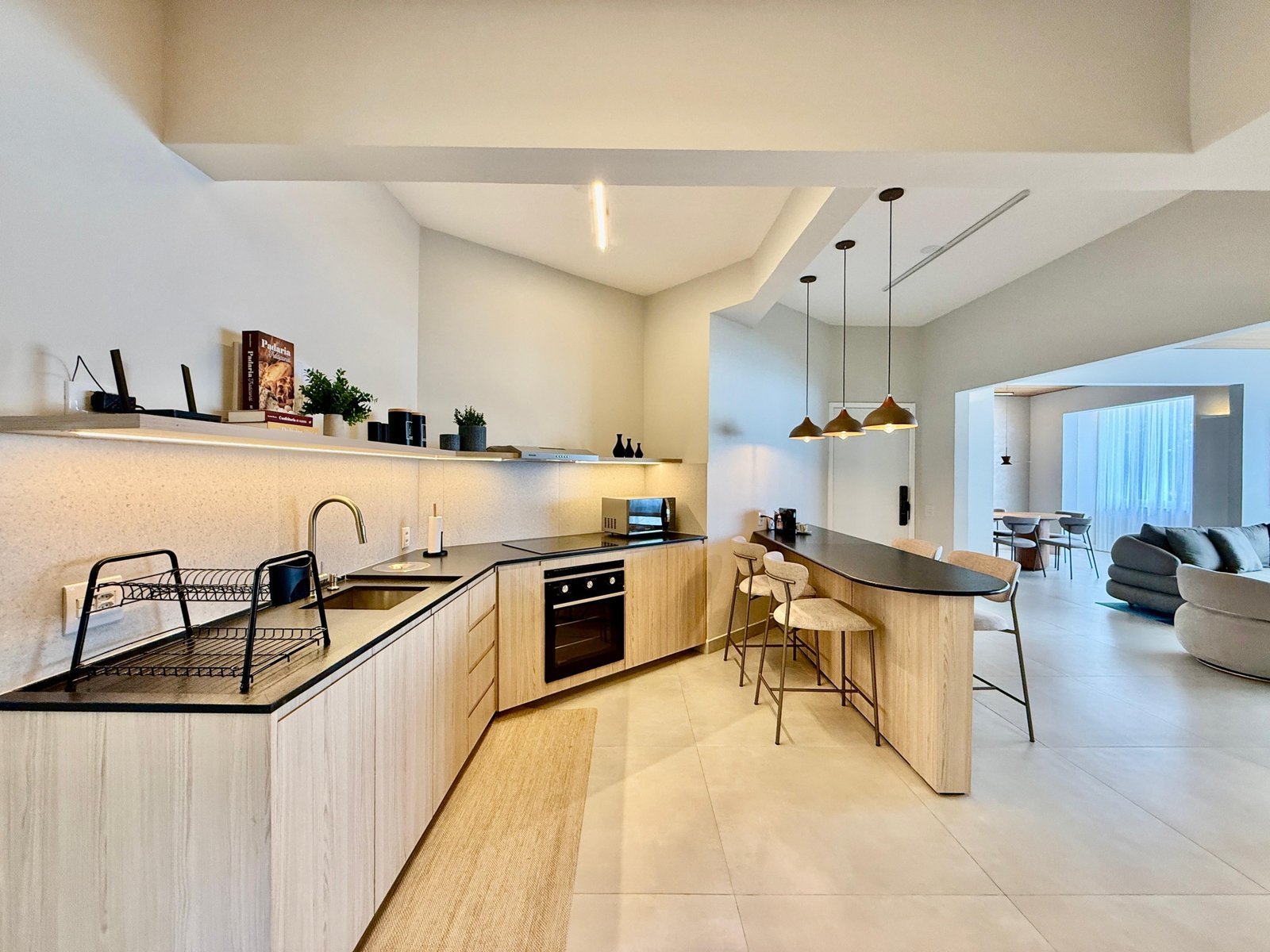 Moderno apartamento de luxo com cozinha planejada, bancadas em granito, áreas de convivência confortável e iluminação elegante, perfeito para morar ou investir.