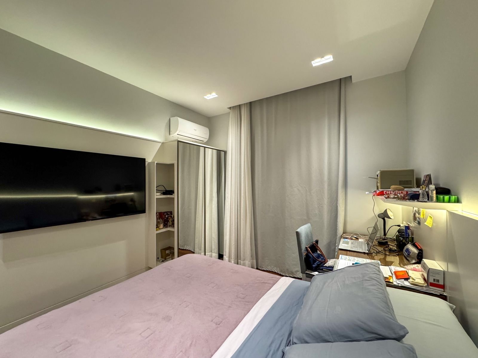 Conjunto de detalhes em ambiente de quarto moderno com televisão de plasma, mesa de estudos, roupas de cama confortáveis e equipamentos eletrônicos, ideal para experiências de hospedagem de alta qualidade.