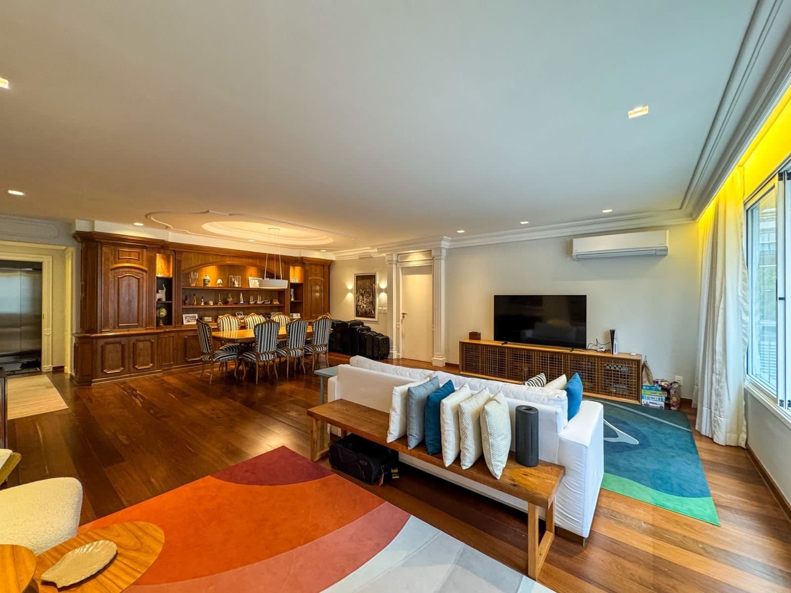 Ambiente sofisticado de sala de estar com móveis elegantes, piso de madeira e decoração moderna, ideal para eventos e reuniões de alta classe, na exclusividade do Grupo Monaco.