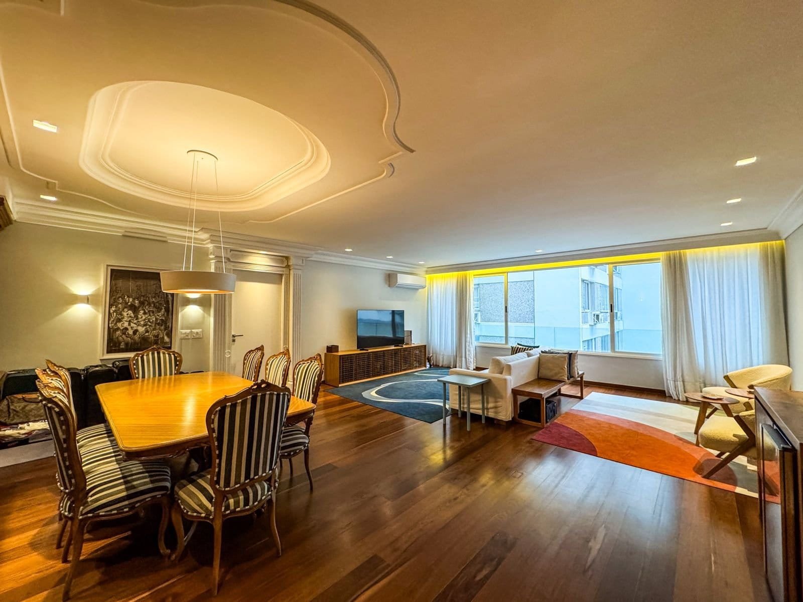 Modernidade e elegância em apartamento do Gruppo Monaco com excelente iluminação natural, conjunto de móveis de madeira e sofás confortáveis em ambiente amplo e aconchegante.